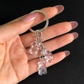 Detail showing three transparent gummy bear resin charms with silver metal keychains - White