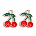 Detailed view of cherry charms with red fruits and green leaves for DIY jewelry making - Cherry