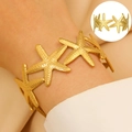 Golden starfish cuff bracelet with textured star charms for a beach summer style look - Granular Relief Starfish