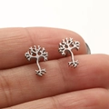 Detail of silver tree of life stud earrings featuring intricate cut-out design - Steel