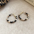 Detalle de pendientes de aro con estampado de leopardo y acabado dorado sobre fieltro beige - Beige & Marrón - 3cm