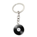 Detail of a retro vinyl record keychain featuring silver metal frame and glossy glass dome - Vintage Texture