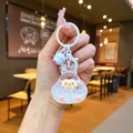 Handheld close-up of a bunny acrylic keychain with glitter and cute pink paw details - Colorful Hardware Keychain Style / Luminous Bubble Beads Tata (White)