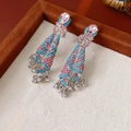 Dettaglio macro di orecchini vintage con strass rosa e perle azzurre con nappine - Perno in argento-Blu