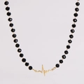 Detailansicht der schwarzen Glasperlen mit einem goldenen EKG-Herzschlag-Anhänger - Herzschlag