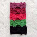 Detail of five assorted ribbed nylon baby bow headbands in vibrant colors on white lace - Deep Tones (Purple/Wine/Red/Green/Black)