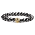 Detailed shot of hematite beaded bracelet featuring a golden lion head charm on white background - Gold Lion Head