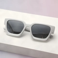 Close-up of matte silver square frame sunglasses on a minimalist white platform - Silver Matte Frame Gray Lens