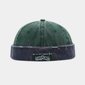 Macro shot of distressed brim edge on vintage forest green and navy denim brimless cap - Dark Green