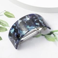 Close-up of blue tortoiseshell acetate U-shaped hair clip with polished finish and green leaf decoration - Navy Blue