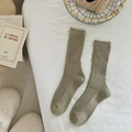 Sage green ribbed cotton mid-calf socks displayed on a white bed in a cozy home setting - One Size / Grey Green