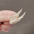 Close-up of a golden wing brooch with micro-pave crystals showing intricate metal details - 441# Gold Feather