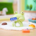 Green Capybara frog resin figurine holding a blue sign on a car dashboard - Temporary Frog (1188-35)