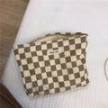 Detail of checkered corduroy makeup bag featuring a Simple Wish fabric label and zipper - Khaki Plaid