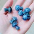 Blue natural stone mushroom miniatures held in hand for size display - Blue Spot Stone