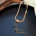 Dettaglio della collana con farfalla in oro rosa con texture opaca ed eleganti nappe pendenti - Collana / Oro Rosa - Catena a Serpente con Nappa a Farfalla Opaca