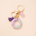 Letter O keychain with purple resin glitter, suede tassel and golden hardware - Letter O