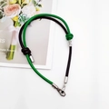 Detail of green and black braided DIY strap with silver metal lobster clasp on white surface - Black + Green
