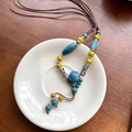 Dettaglio di una collana etnica vintage con perline di ceramica blu e gialle su piatto - Stile Ceramica in Metallo Intagliato (18# Collana-Caffè-Blu-Giallo)