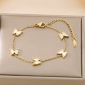 Detail of gold butterfly bracelet with white shell charms in a luxury jewelry box - White (KB187204-BI)