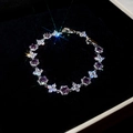 Primer plano de una pulsera de plata con gemas púrpuras sobre terciopelo negro - Morado