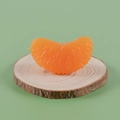 Realistische Orangenstück-Kerze in Orange mit Fruchtfleisch-Textur auf Holz - 3,8 cm großes einzelnes Orangensegment - Modell ohne Schnalle