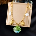 Detailopname van gouden halsketting met kleurrijke schelp-, zeester- en zonhangers - Schildpad Maan Parel Multi-Hanger Stijl (N3463)