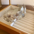 Détail du serre-tête papillon en métal argenté posé sur un coffret à bijoux en bois - Argenté