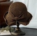 Dark brown handmade straw sun hat with large bow decoration on wooden stand - L (58-60cm) / Solid Bow Decor Caramel