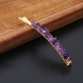 Goldene Haarspange mit lila Naturkristallsteinen auf einem Holztablett serviert - Amethyst Gold