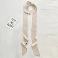 Elegant champagne gold long silk scarf tied as a hair ribbon on a textured white background - 190*5cm / Apricot