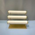 Three-tier jewelry display stand with beige velvet rollers and gold metal base - 3-Tier Bracelet Stand / Off White