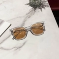 Gafas de sol cuadradas de moda con montura transparente y lentes ámbar sobre mármol - Montura Transparente Lentes Marrones