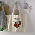 Detail of off-white canvas tote with PERSIMMON print hanging in a minimalist home setting - PERS (Large Capacity)