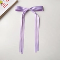 Gros plan détaillé d'une pince à cheveux nœud en satin violet sur un fond esthétique - Violet