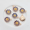 Blue and yellow enamel daisy flower charms with gold edges arranged on a white plate - Blue