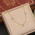 Dettaglio della collana a quadrifoglio dorata con perle turchesi su libro vintage - Quadrifoglio (1# Fiore)