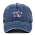 Close-up of pink TANNED and TIPSY embroidery on a washed navy blue cotton baseball cap - Adjustable / Navy Blue