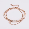 Detailed macro view of rose gold double-layer chain bracelet with sparkling crystal accents - Rose Gold