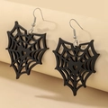 Makro-Detail von schwarzen Gothic Spinnennetz-Ohrringen mit Herzdesign auf beigem Dekor - Schwarzes Spinnennetz Ohrhaken