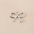 Macro shot of a silver bow-shaped copper pendant featuring a brilliant white zircon stone - Single Stone End Bow (PJ0129-1#) / Silver