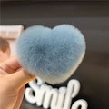 Close-up of a blue heart-shaped plush hair clip made from genuine rabbit fur material - Haze Blue