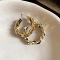 Detailed view of leopard print fabric intertwined with golden twisted chain earrings - Gold-tone Amber Twisted Hoop Style (No. 5 Silver Earring Post - Gold & Dark Brown)