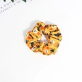 Detailed top view of a yellow Halloween scrunchie with ghost, bat, and spider patterns - Yellow