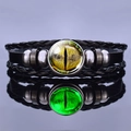 Detailansicht eines leuchtenden Drachenauge-Glas-Cabochons auf schwarzem Lederarmband - Gelbes Auge-Stil