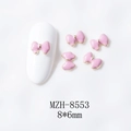 Vista macro de mini dijes de lazo rosa de 8x6mm para uñas con bordes dorados finos - Rosa