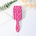 Detailed top view of a pink leopard print air cushion hairbrush with decorative florals - Pink Leopard
