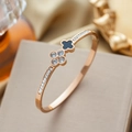 Roségouden titanium klaver armband met zwart inlegwerk en diamanten op een doosje - Roségoud