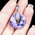 Blue and white sodalite stone donut pendant with silver bail shown in hand - 20mm Blue Spot Jade