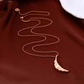 Nahaufnahme der Croissant-Mond-Halskette mit 18k Roségold-Beschichtung auf Seidenhintergrund - Gold